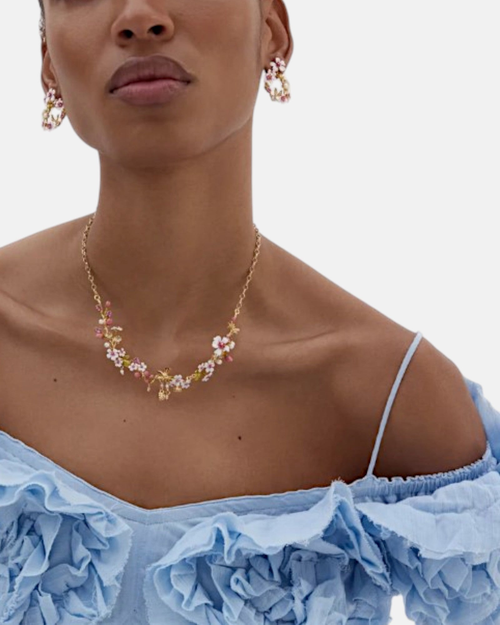 Modelo luciendo los pendientes de aro Les Néréides de cerezos en flor esmaltados con el collar de la misma colección floral.