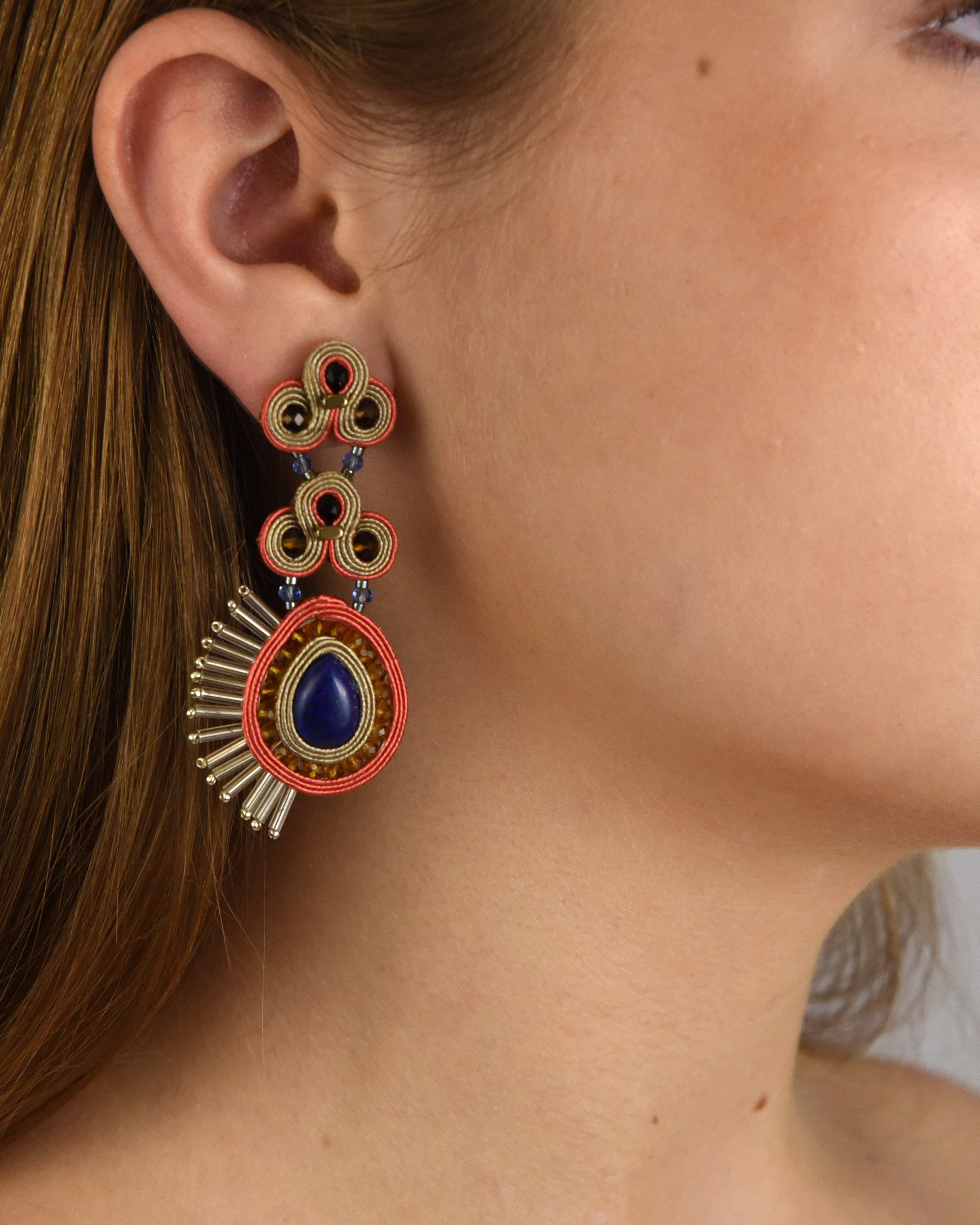 Mujer luciendo los pendientes Micaela Ice, destacando su elegancia y el contraste del azul lapislázuli con el coral.