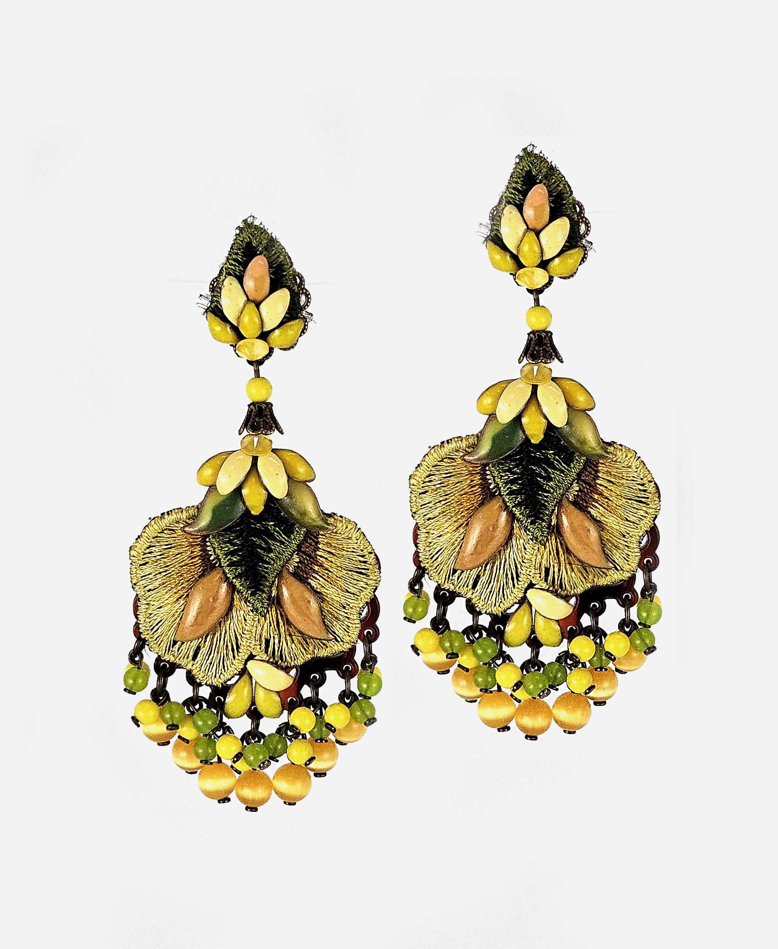Pareja de pendientes Dublos con bordado de seda en verde y oro, con cascada de cuentas amarillas sobre fondo blanco.