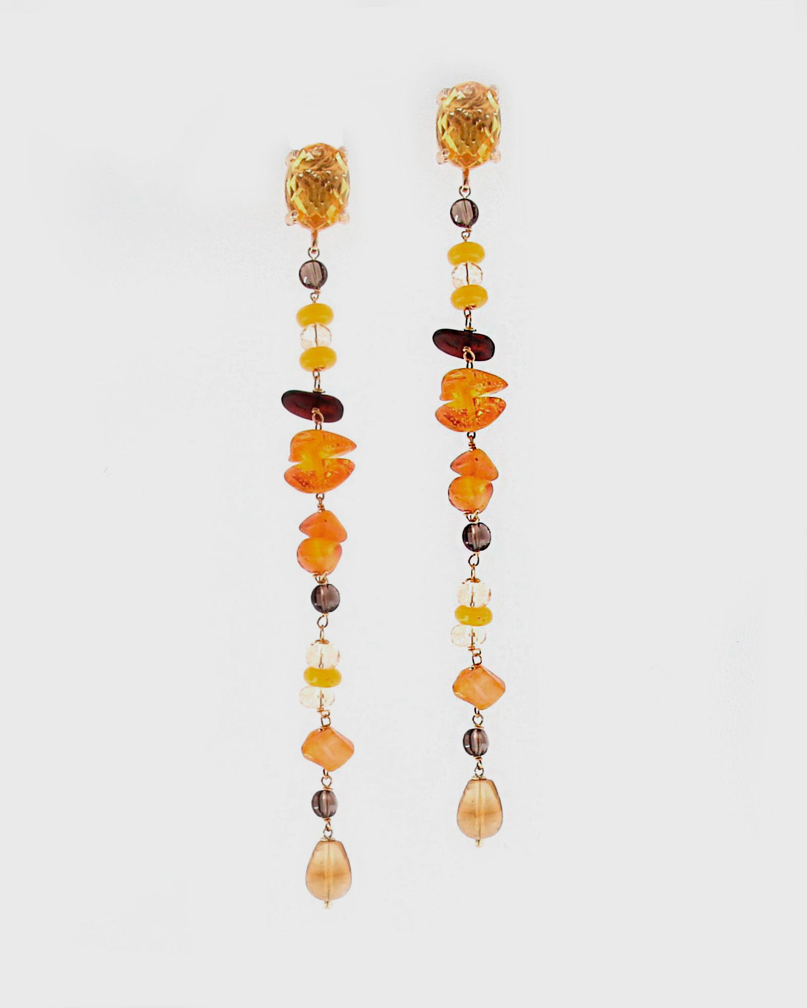 Pareja de pendientes lineales Amlé con hilera de piedras naturales de ámbar, cuarzo y ágatas amarillas sobre fondo blanco.