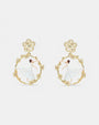 Par de pendientes de botón Les Néréides Pas de Deux con bailarina esmaltada en blanco dentro de un aro floral dorado.