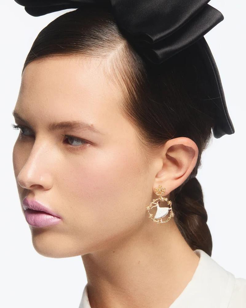 Modelo luciendo los pendientes de bailarina Les Néréides Pas de Deux combinados con un tocado de lazo negro.