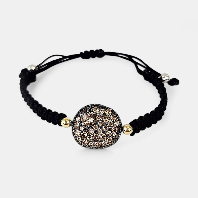 Pulsera de macramé negro Bohemme Musa con medallón central de plata oxidada y pavé de circonitas champagne.