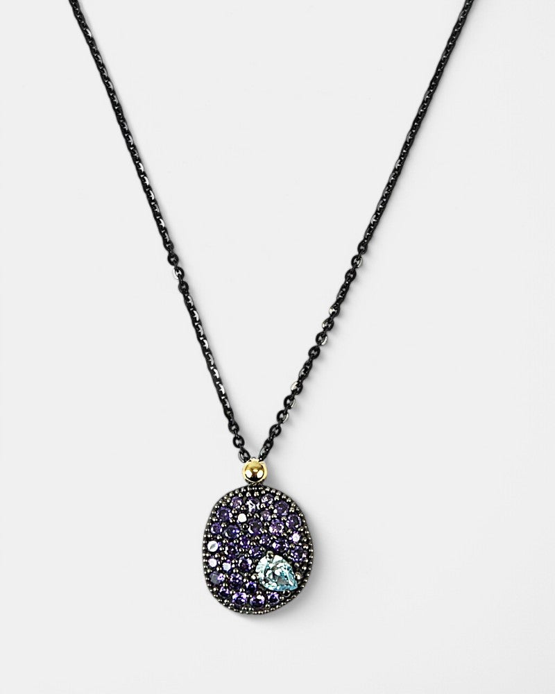 Collar Bohemme Musa con colgante ovalado de plata oxidada y pavé de circonitas violetas con gema azul.