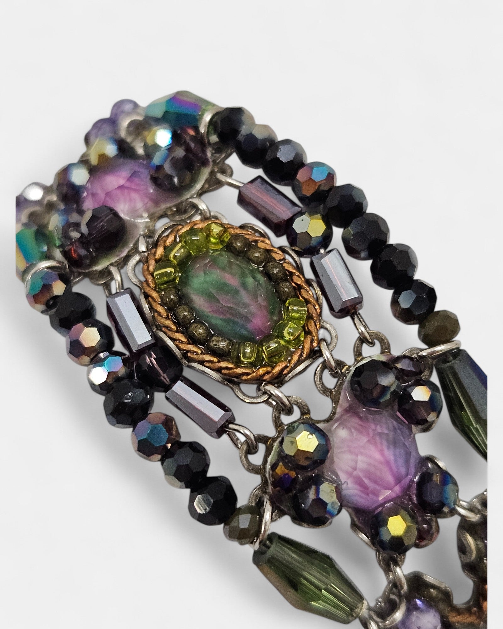 Pulsera artesanal con cristales y esmalte en tonos amatista, verde y fucsia