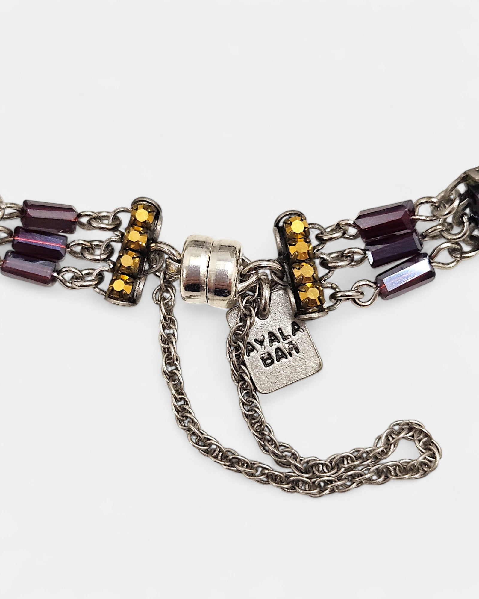 Pulsera artesanal con cristales y esmalte en tonos amatista, verde y fucsia