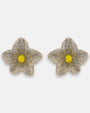 Pendientes "Pétalos de Luz" con diseño floral bordado en tonos plata y centro amarillo cítrico sobre fondo claro.