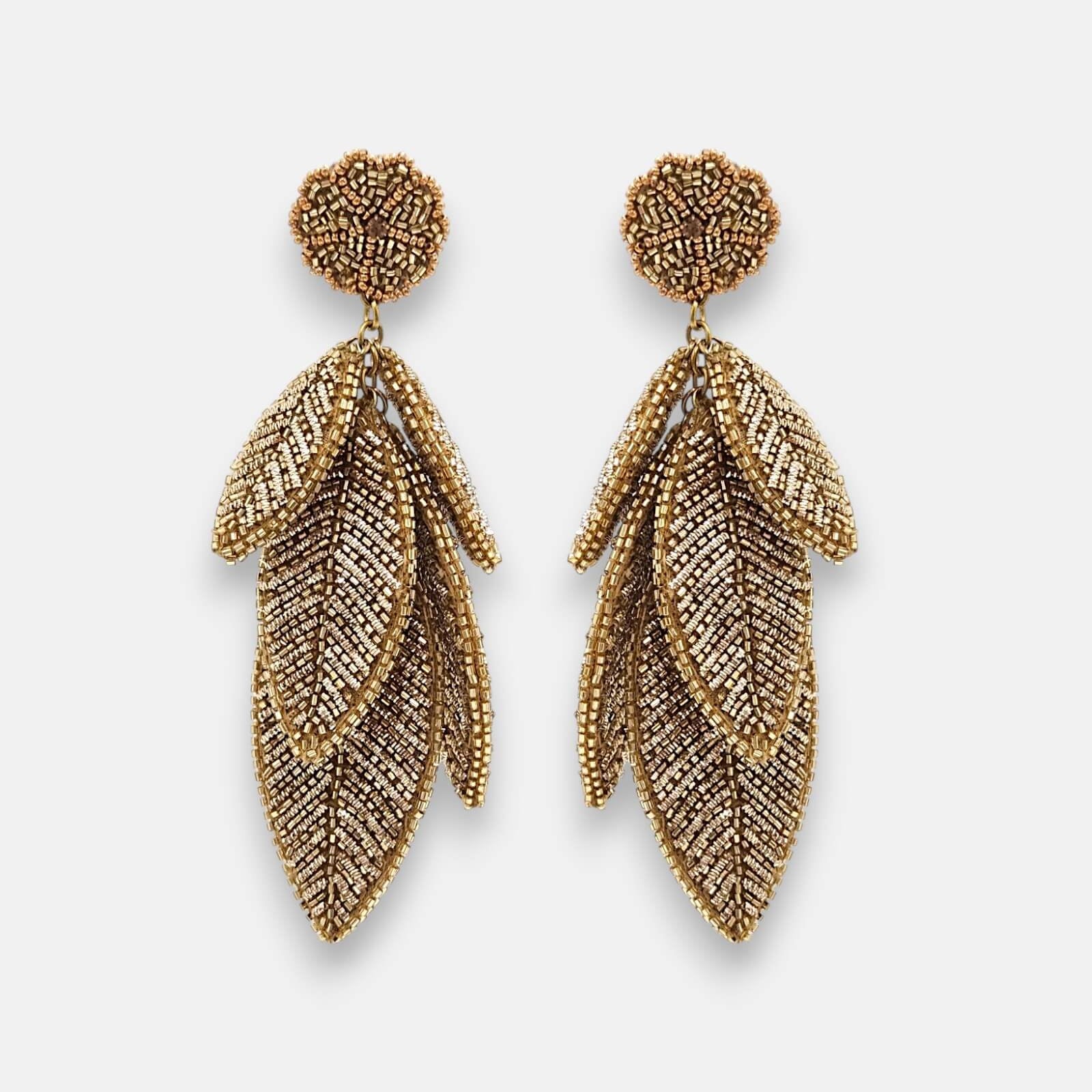 Pendientes "Bruma de Oro" con diseño de hojas escalonadas bordadas en hilos metálicos dorados sobre fondo claro.