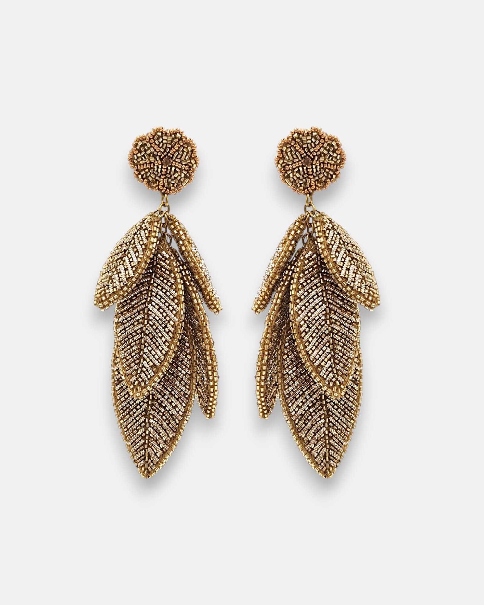 Pendientes "Bruma de Oro" con diseño de hojas escalonadas bordadas en hilos metálicos dorados sobre fondo claro.