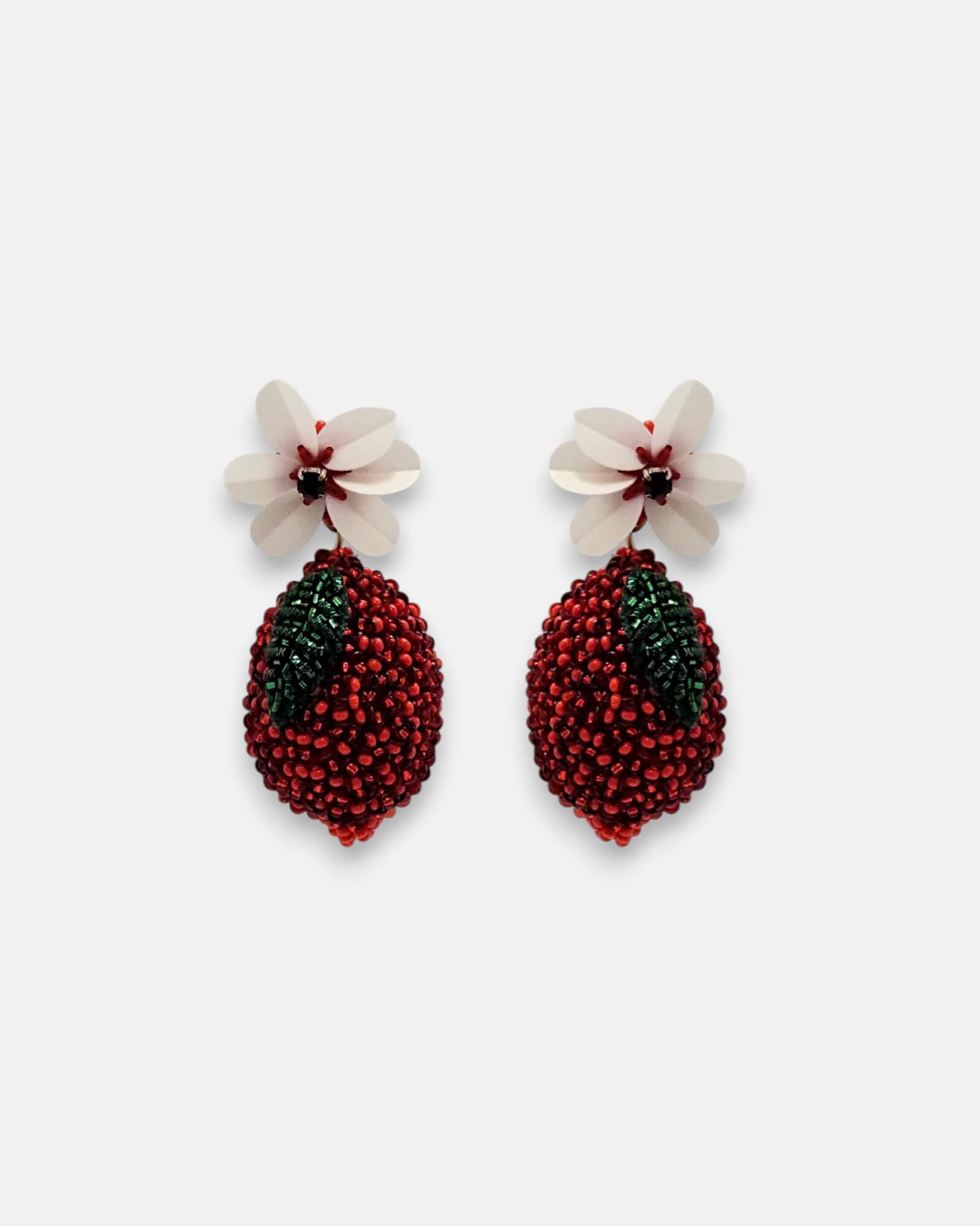 Pendientes "Fruto Prohibido" en forma de fruto rojo bordado con flor blanca superior sobre fondo claro.