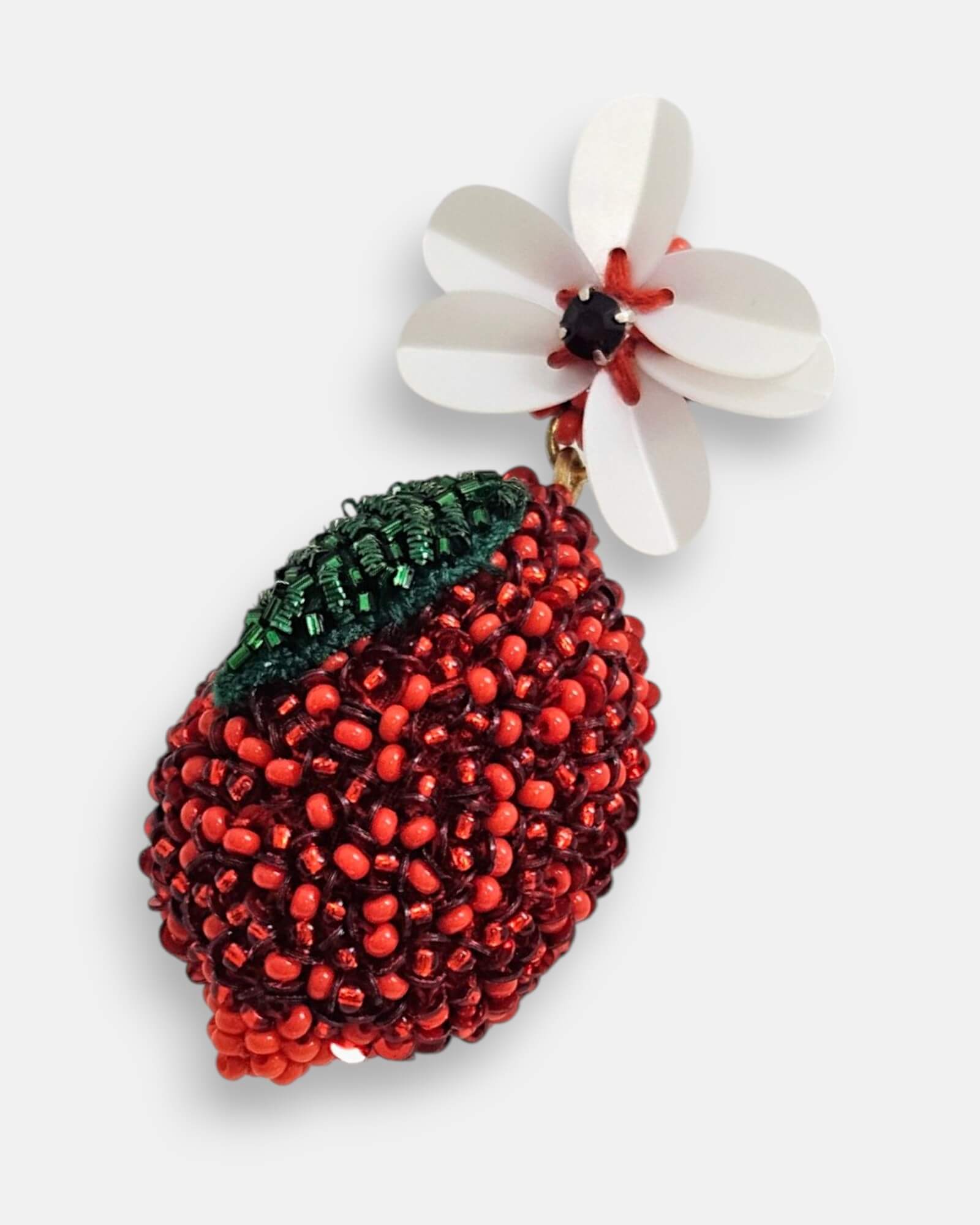 Primer plano macro del bordado del fruto rojo y la hoja esmeralda de los pendientes "Fruto Prohibido".