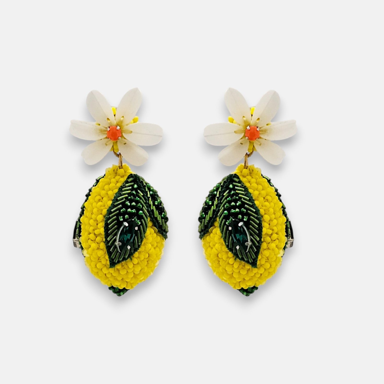 Pendientes "Citric Joy" en forma de limón bordado con flor blanca superior sobre fondo claro.