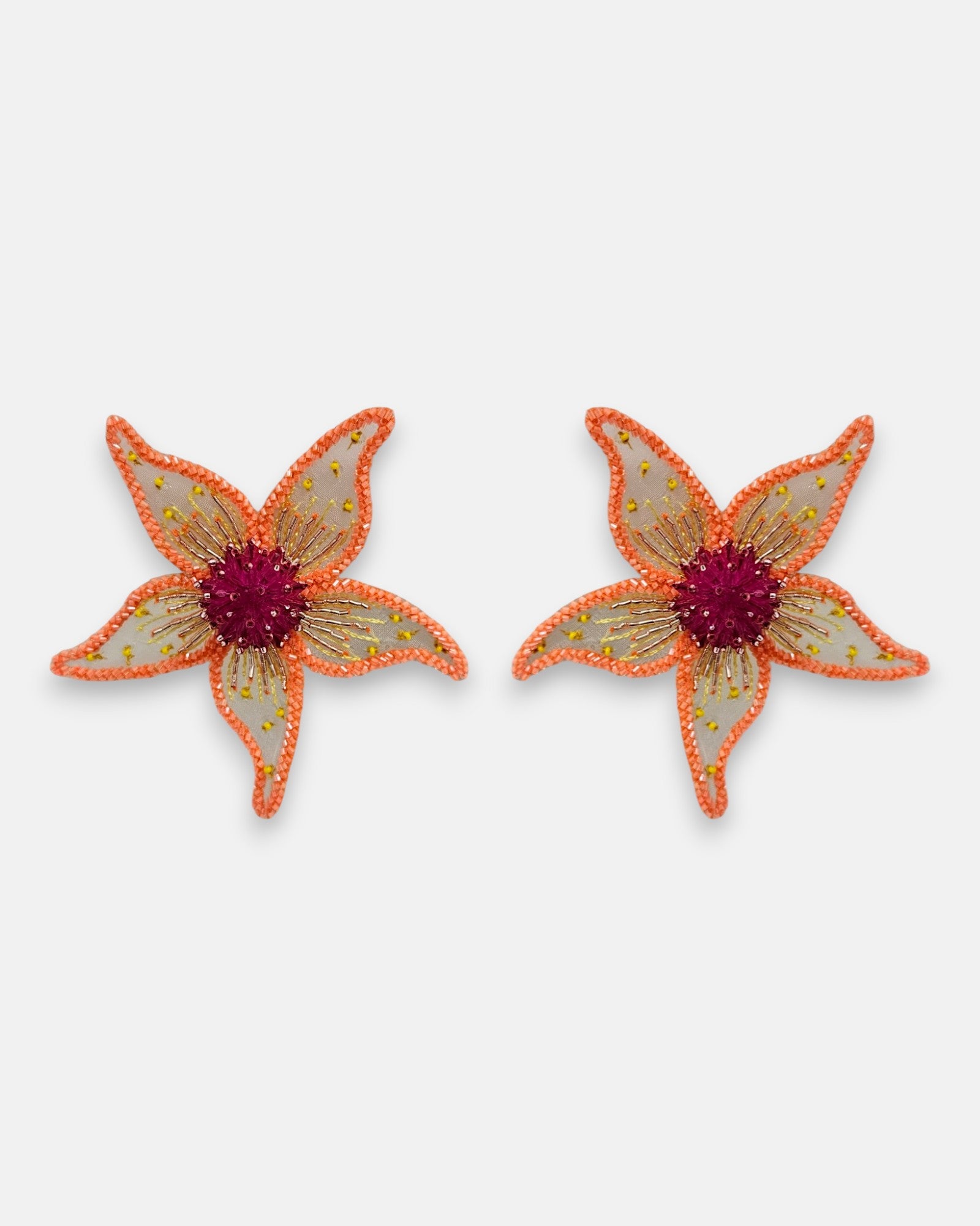 Pendientes "Jardín de Hespérides" con diseño de flor bordada sobre tul en tonos coral y centro carmesí sobre fondo claro.