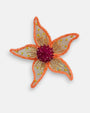 Primer plano detallado del centro carmesí bordado y la textura de los pétalos de los pendientes "Jardín de Hespérides".