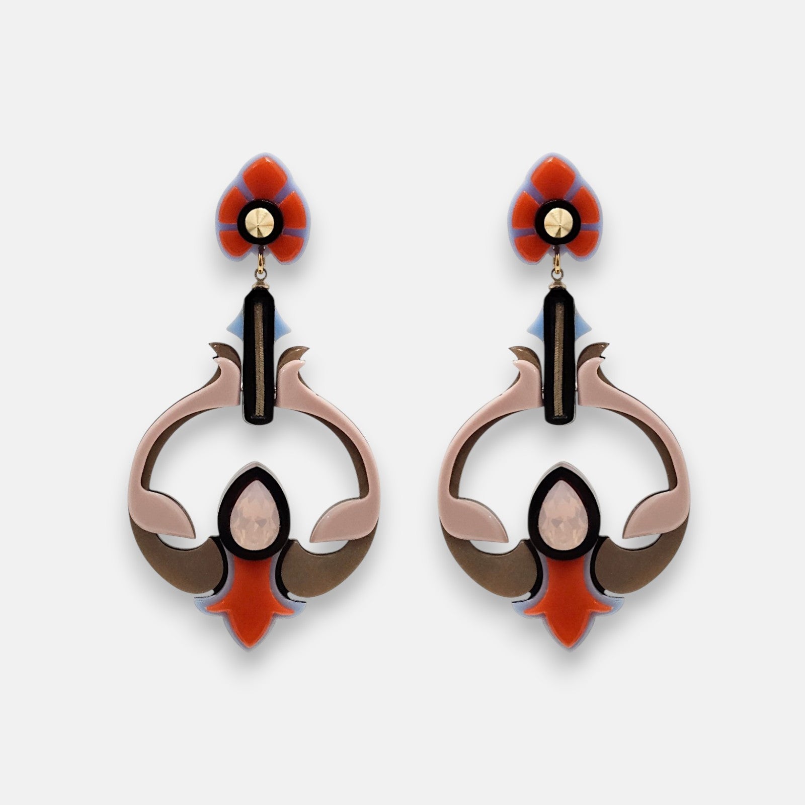 Par de pendientes "Vitraux" de Gissa Bicalho con diseño circular y trébol en resina naranja, rosa y azul sobre fondo blanco.