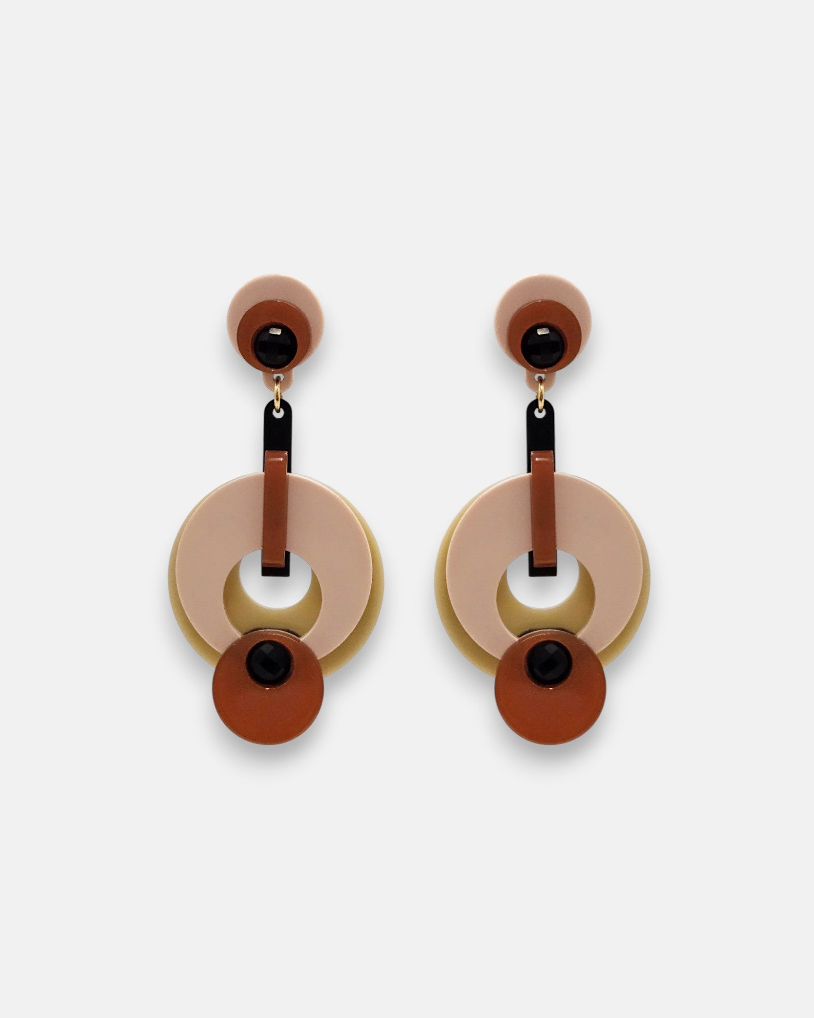 Par de pendientes "Eclipsse" de Gissa Bicalho con diseño de círculos en resina rosa, terracota y verde oliva sobre fondo claro.