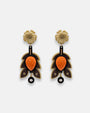 Par de pendientes "Otoño Escultórico" de Gissa Bicalho con diseño de hojas en resina arena, madera y centro naranja sobre fondo claro.