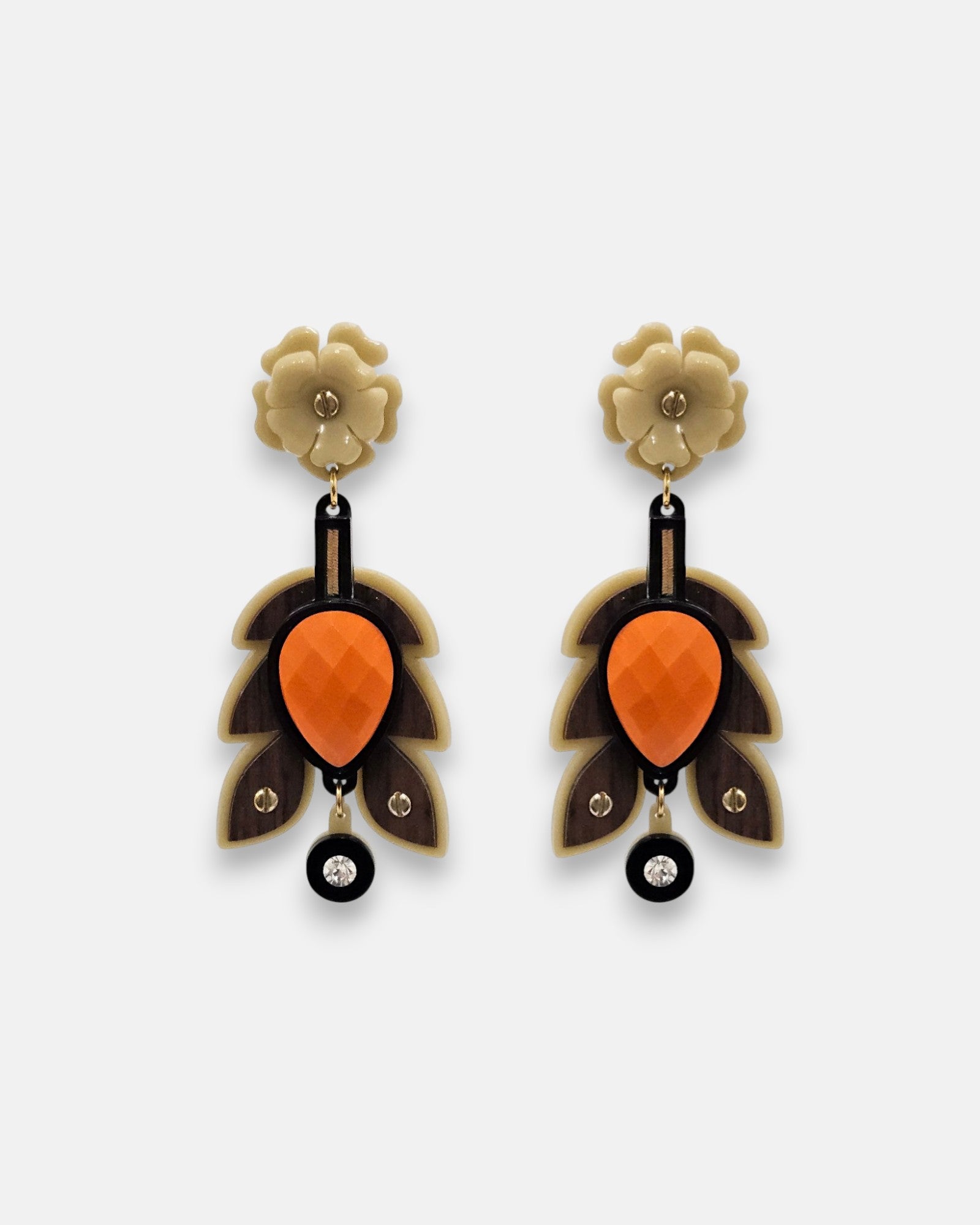 Par de pendientes "Otoño Escultórico" de Gissa Bicalho con diseño de hojas en resina arena, madera y centro naranja sobre fondo claro.
