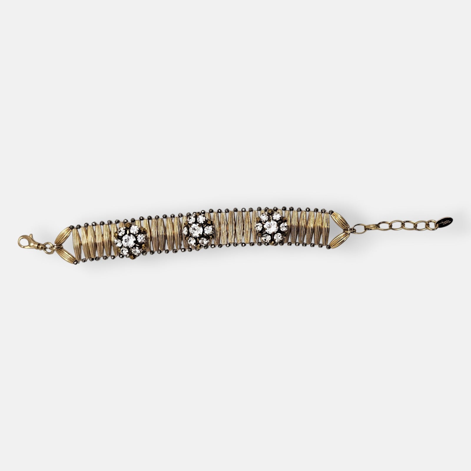 Pulsera Tataborello extendida mostrando la hilera de brotes articulados dorados con perfilado oscuro.