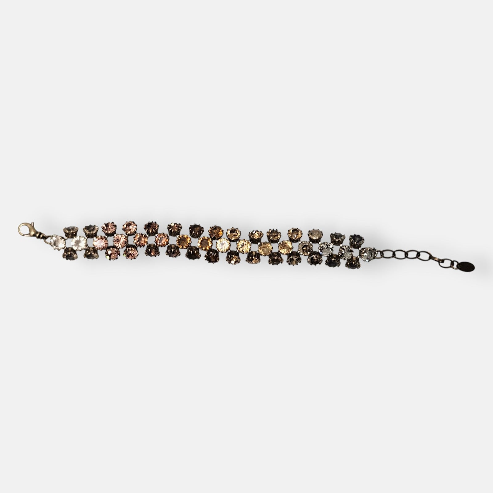 Pulsera Tataborello extendida mostrando la triple hilera de cristales en degradado ámbar y ahumado.