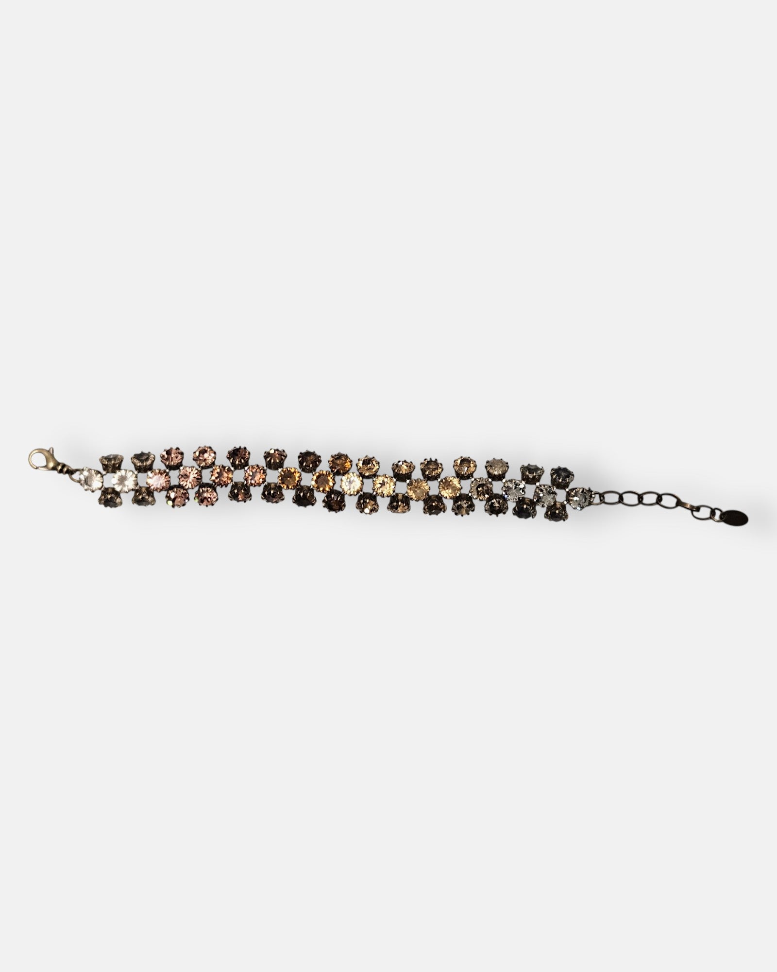 Pulsera Tataborello extendida mostrando la triple hilera de cristales en degradado ámbar y ahumado.