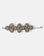 Maxi pulsera ancha Tataborello extendida compuesta por una red de rosetones florales dorados y brillantes.