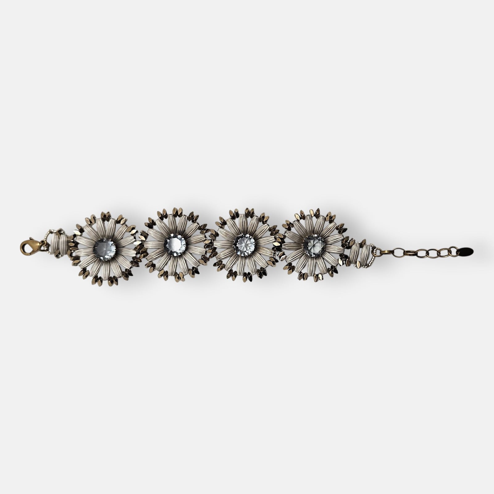Pulsera Tataborello extendida compuesta por cuatro grandes eslabones en forma de flor plateada y cristales centrales grises.