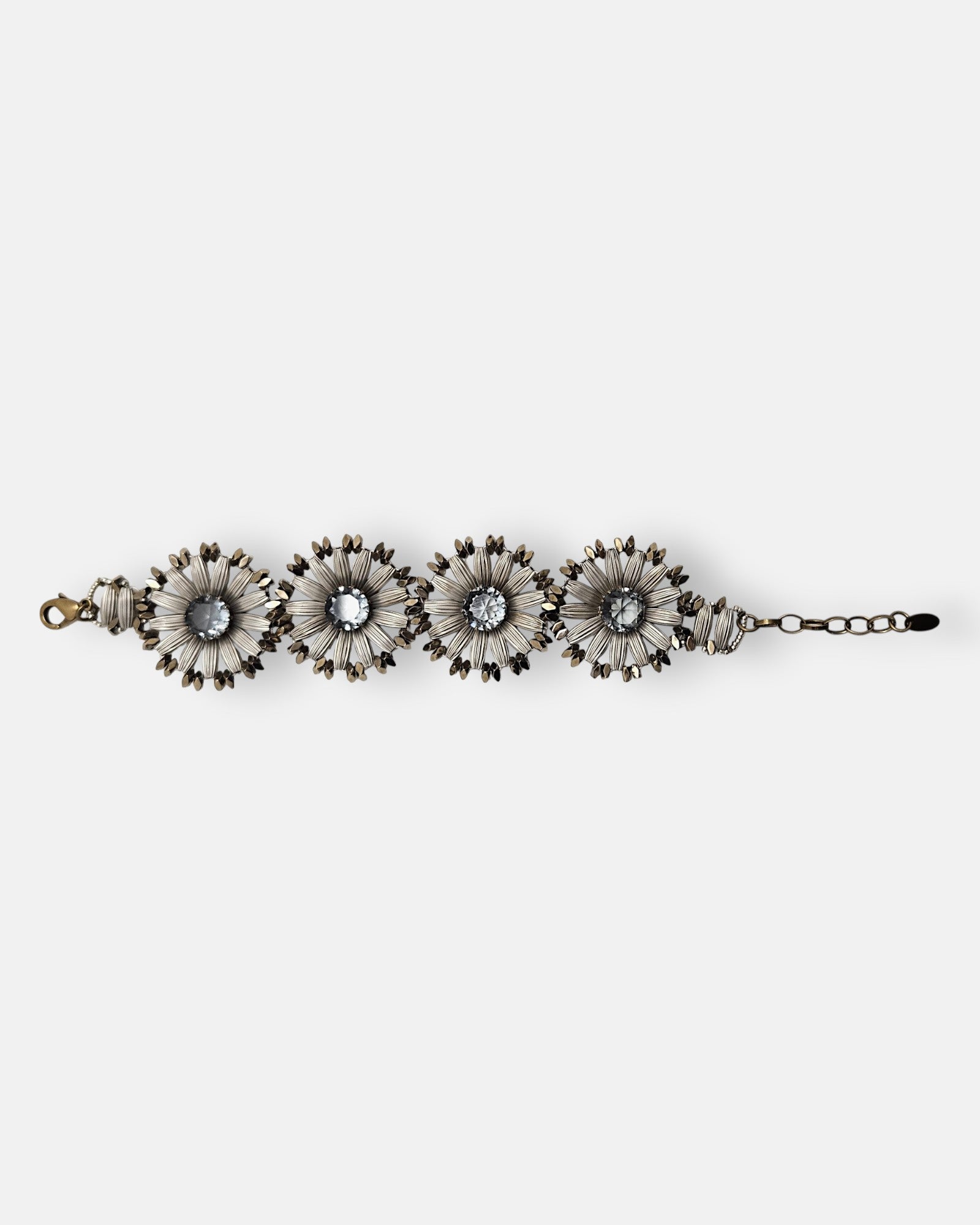 Pulsera Tataborello extendida compuesta por cuatro grandes eslabones en forma de flor plateada y cristales centrales grises.
