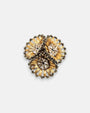 Broche de solapa maxi Tataborello compuesto por tres flores doradas estriadas con cristales en el centro.
