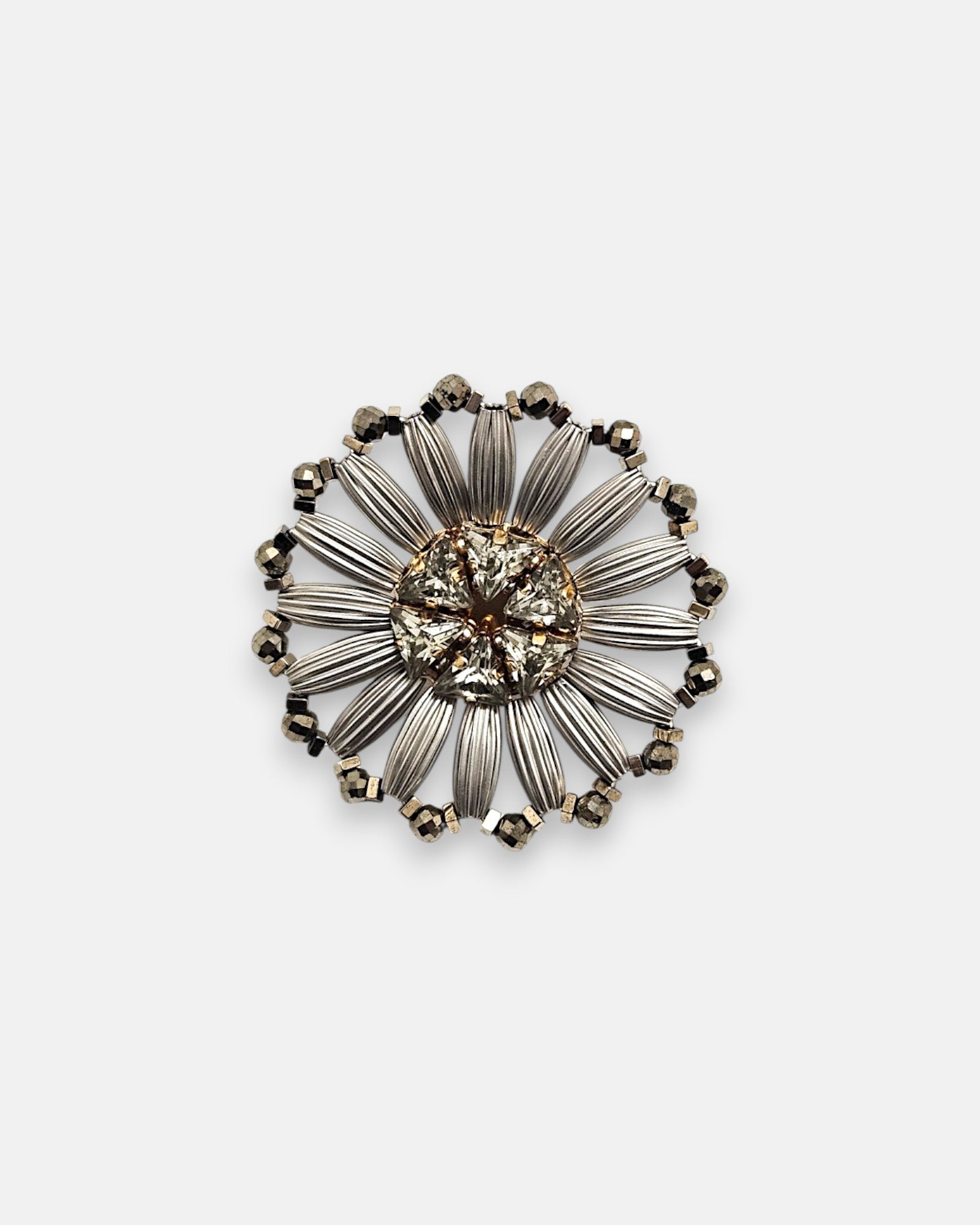 Pin broche redondo Tataborello con diseño de flor calada en rutenio plateado y cristales centrales.