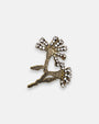 Broche artesanal Tataborello con silueta de rama bordada en canutillos bronce y remates de cristales brillantes.