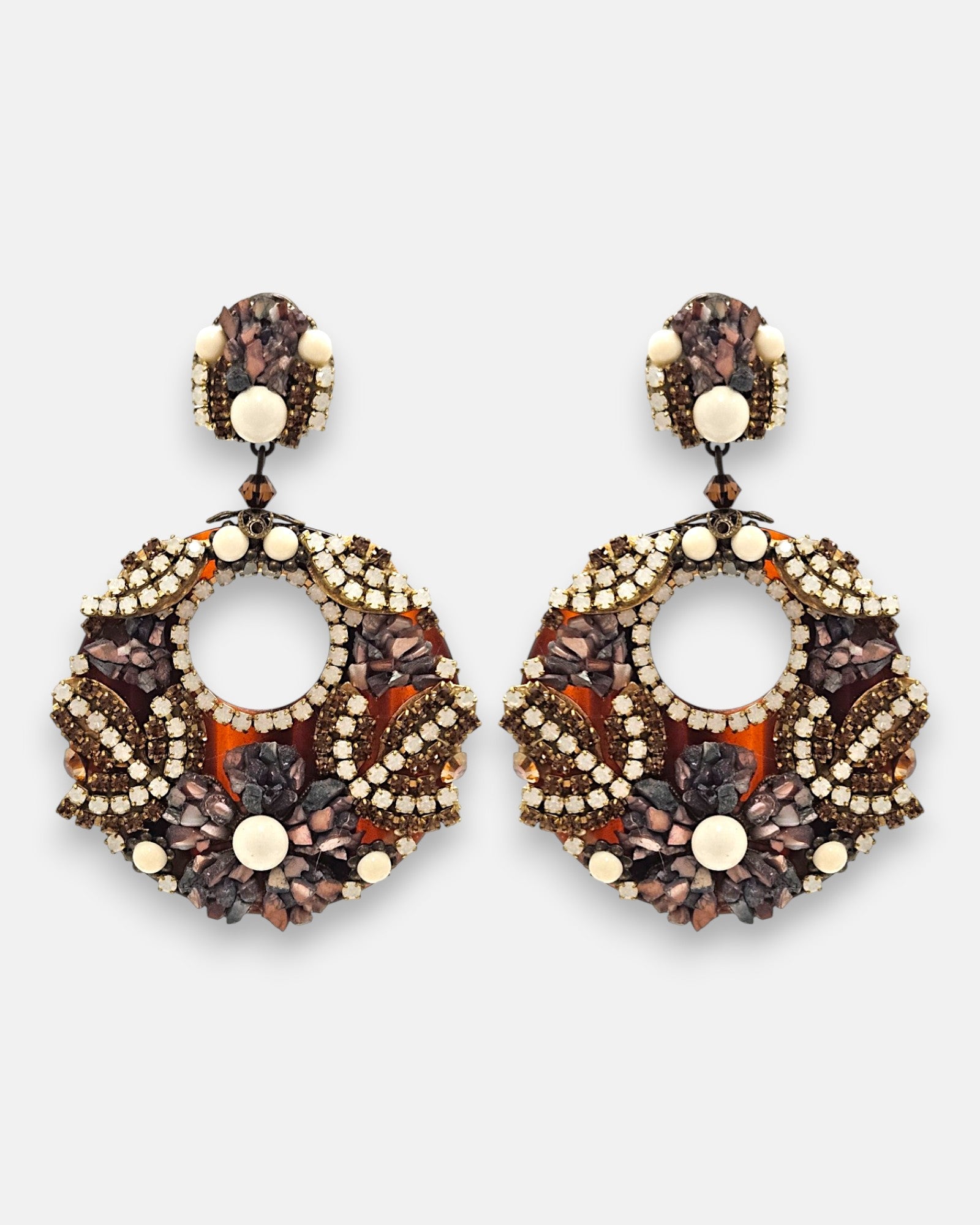 Pareja de pendientes grandes de fiesta en forma de aro Mosaico de Ámbar de Dublos, mostrando su base de carey decorada con strass, piedras en tonos tierra y cuentas marfil.