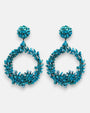 Pareja de pendientes de fiesta grandes en forma de aro abierto Corona de Cícladas de Dublos, mostrando su mosaico texturizado de cuentas y fragmentos en azul claro turquesa.