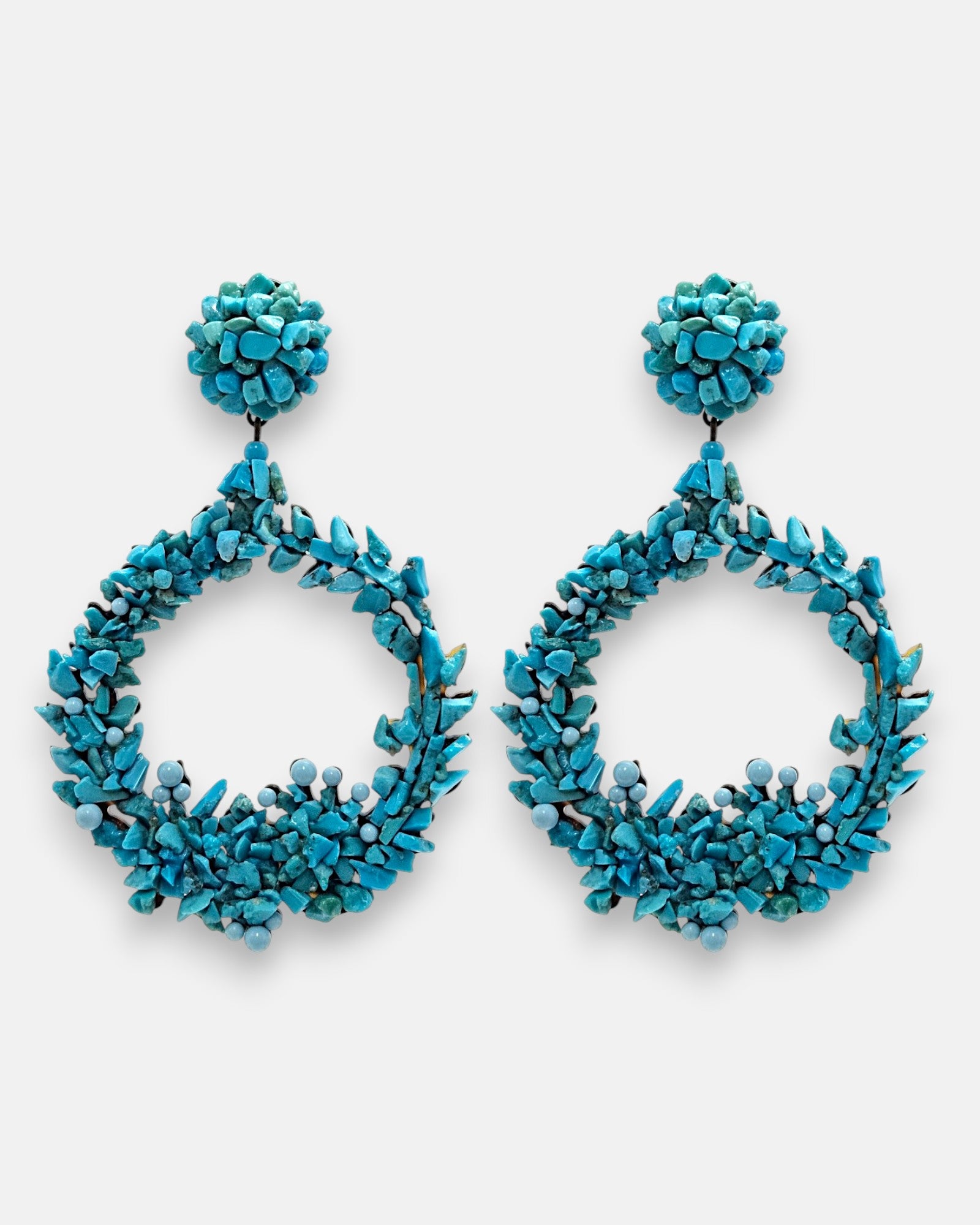 Pareja de pendientes de fiesta grandes en forma de aro abierto Corona de Cícladas de Dublos, mostrando su mosaico texturizado de cuentas y fragmentos en azul claro turquesa.