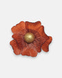 broche de flor de Ciléa Paris sobre fondo neutro, apreciando su diseño de pétalos estriados color naranja terracota con pistilo central dorado.