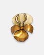 broche maxi con forma de flor de iris sobre fondo neutro, destacando sus pétalos superiores color crema y los inferiores en tono dorado satinado.