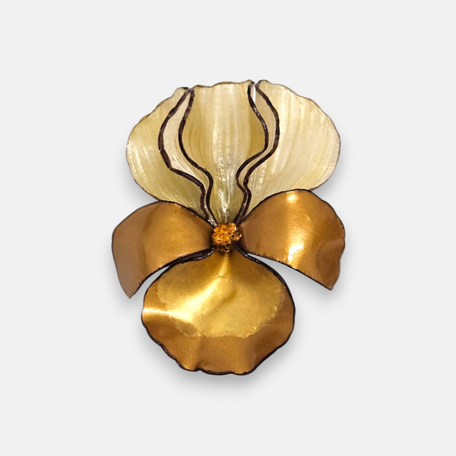broche maxi con forma de flor de iris sobre fondo neutro, destacando sus pétalos superiores color crema y los inferiores en tono dorado satinado.