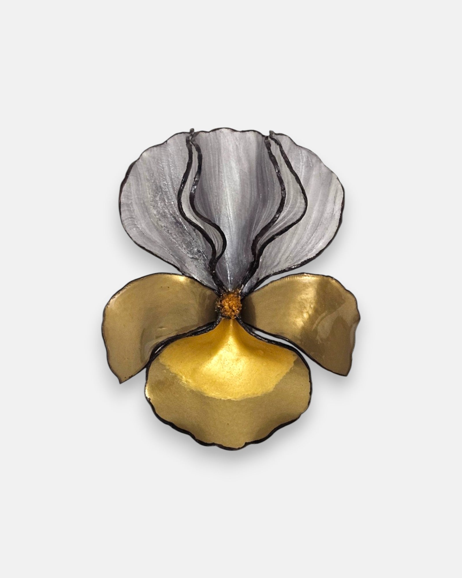 broche con forma de flor de iris sobre fondo neutro, resaltando sus pétalos superiores plateados y la base metálica en tonos oro.