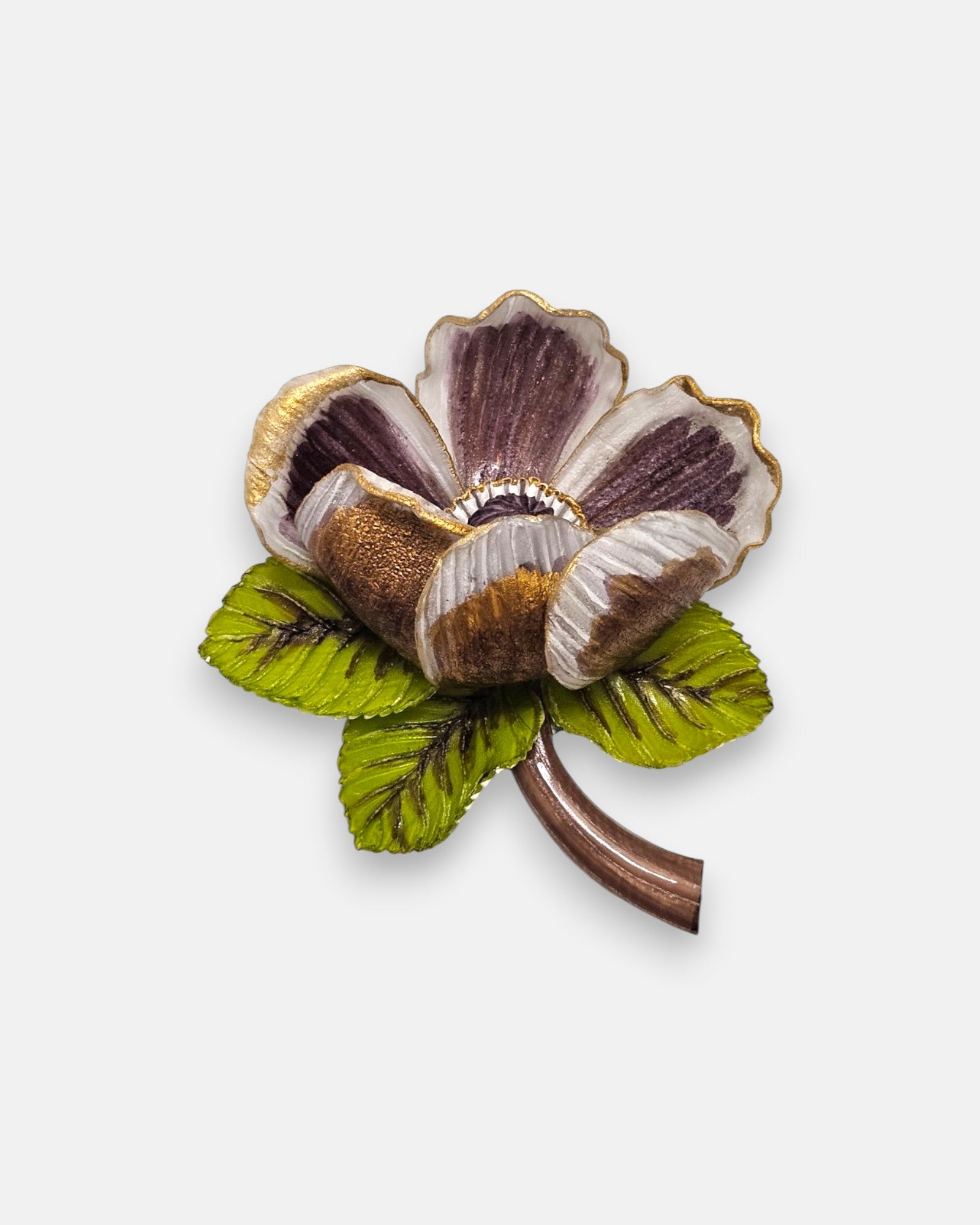 broche de flor silvestre de Ciléa Paris sobre fondo claro, apreciando sus pétalos estriados violetas con bordes dorados, sus hojas verdes y su tallo marrón.