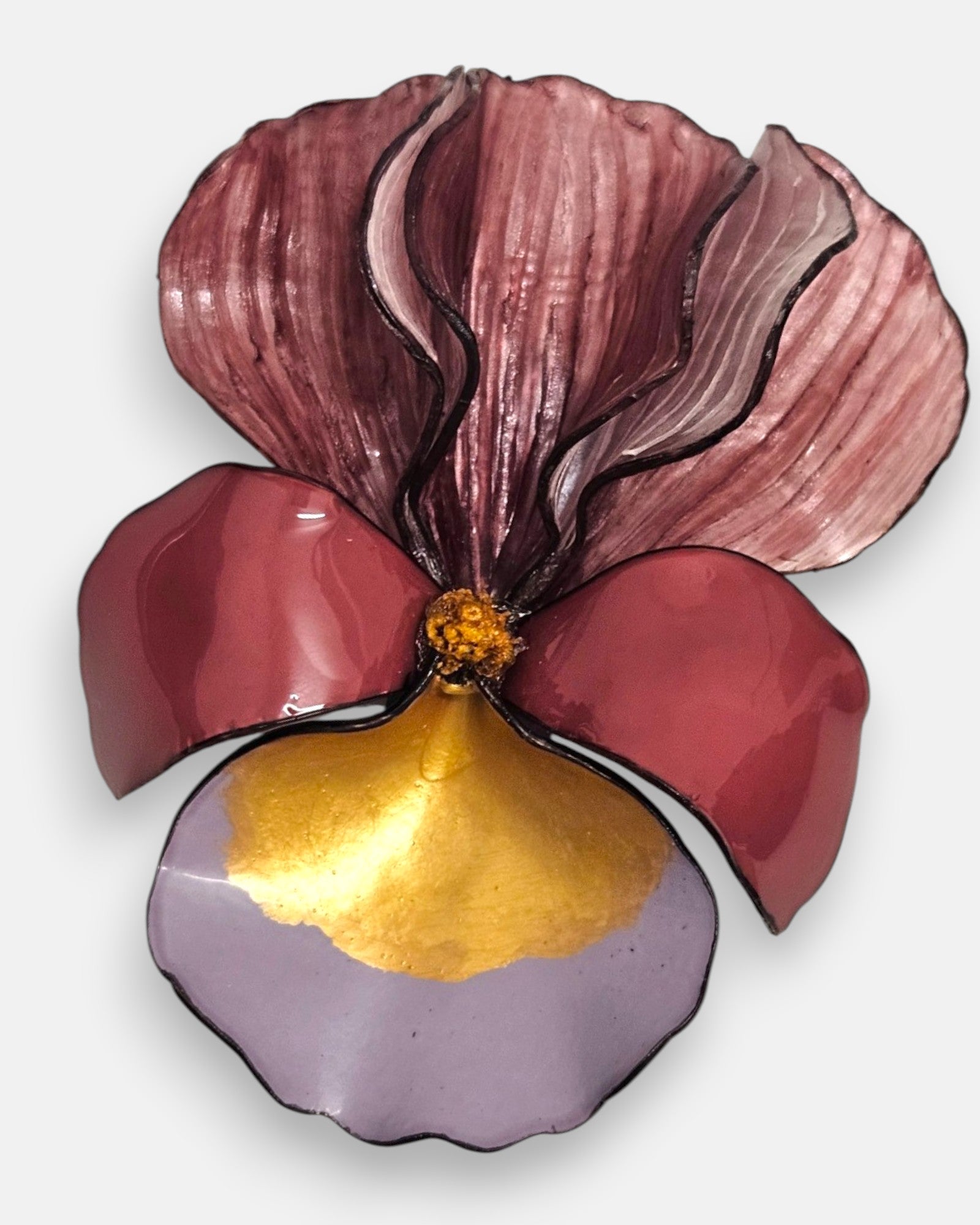 primer plano macro en ángulo del broche floral, permitiendo apreciar el brillo esmaltado de los pétalos de resina inferiores y el relieve estriado de la sección superior.