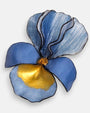 primer plano macro en ángulo del broche floral, permitiendo apreciar el brillo esmaltado de los pétalos de resina inferiores y el relieve estriado de la sección azul superior.