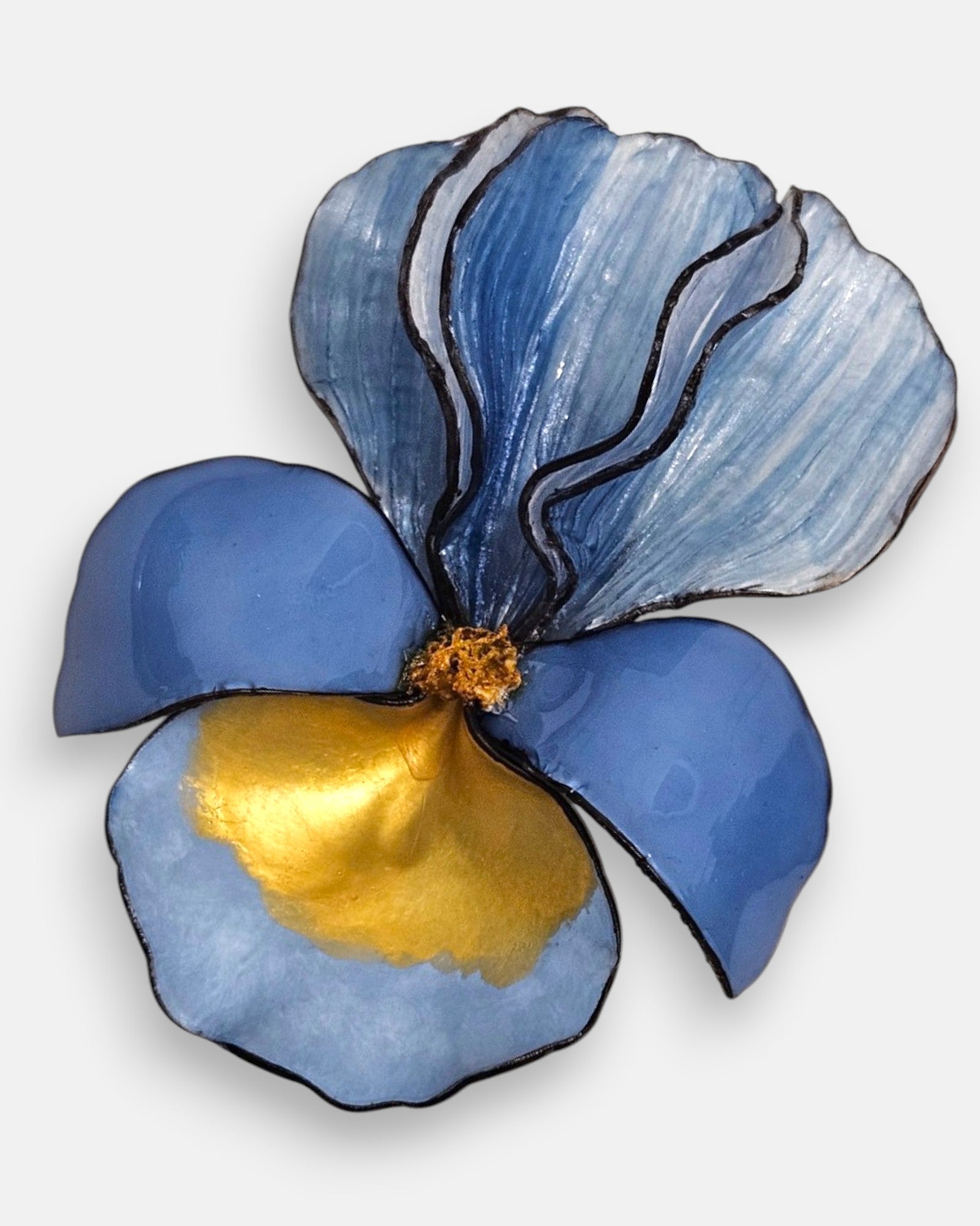 primer plano macro en ángulo del broche floral, permitiendo apreciar el brillo esmaltado de los pétalos de resina inferiores y el relieve estriado de la sección azul superior.