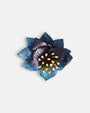 broche con forma de flor de loto de Ciléa Paris sobre fondo claro, apreciando la disposición de sus capas en resina translúcida de color azul y su centro de pistilos.