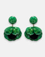 par de pendientes con forma de flor de amapola de Ciléa Paris sobre fondo claro, detallando su botón superior redondo y sus pétalos volumétricos en verde esmeralda con centro negro.
