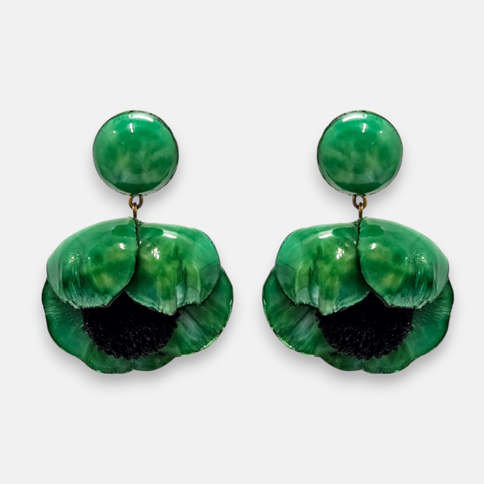 par de pendientes con forma de flor de amapola de Ciléa Paris sobre fondo claro, detallando su botón superior redondo y sus pétalos volumétricos en verde esmeralda con centro negro.