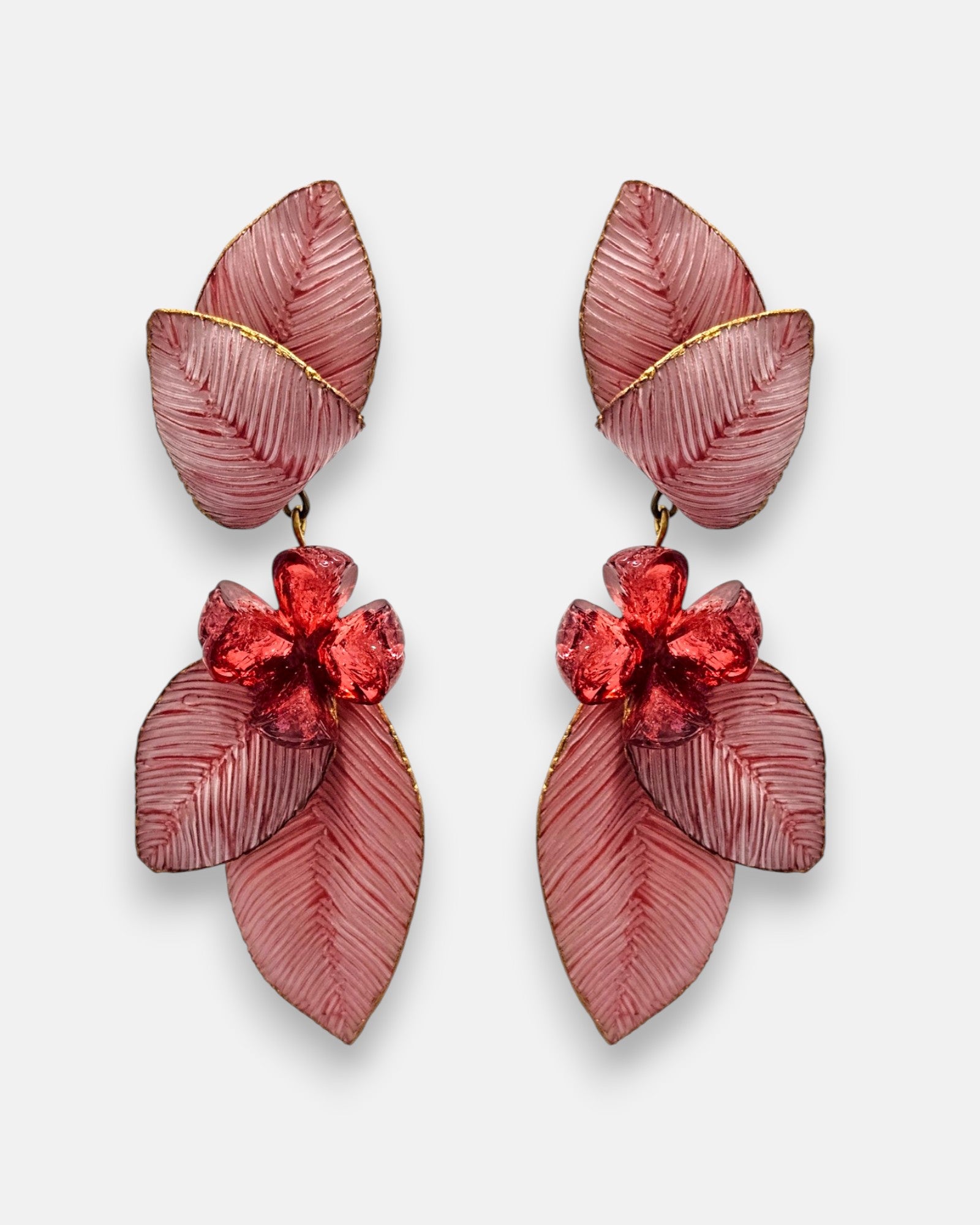 par de pendientes largos de clip de Ciléa Paris sobre fondo claro, detallando su estructura de hojas estriadas rosa nácar con bordes dorados y una flor central color rojo rubí.