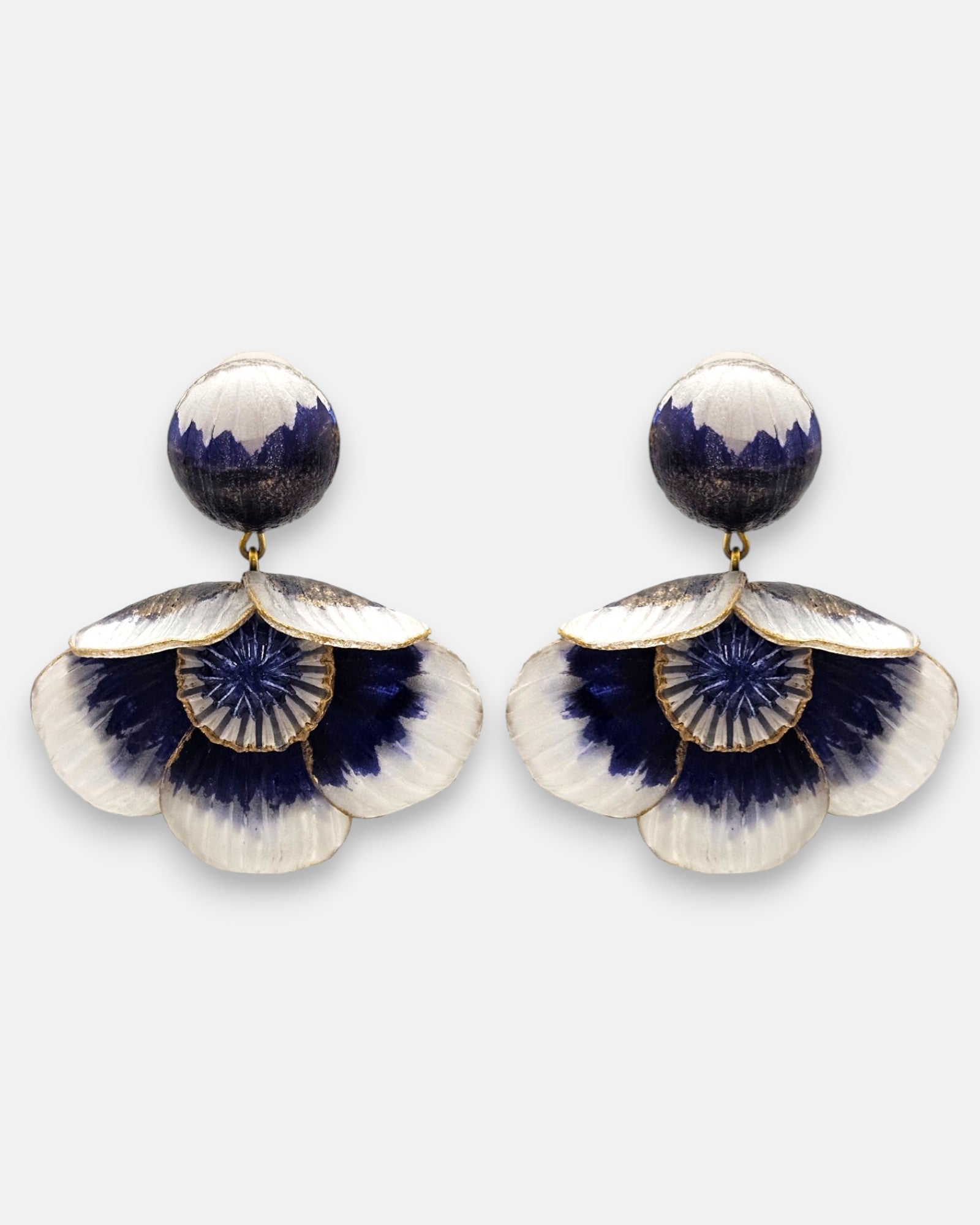 par de pendientes de presión con forma de flor de Ciléa Paris, detallando su botón superior redondo y sus pétalos degradados en blanco y azul cobalto con bordes dorados.