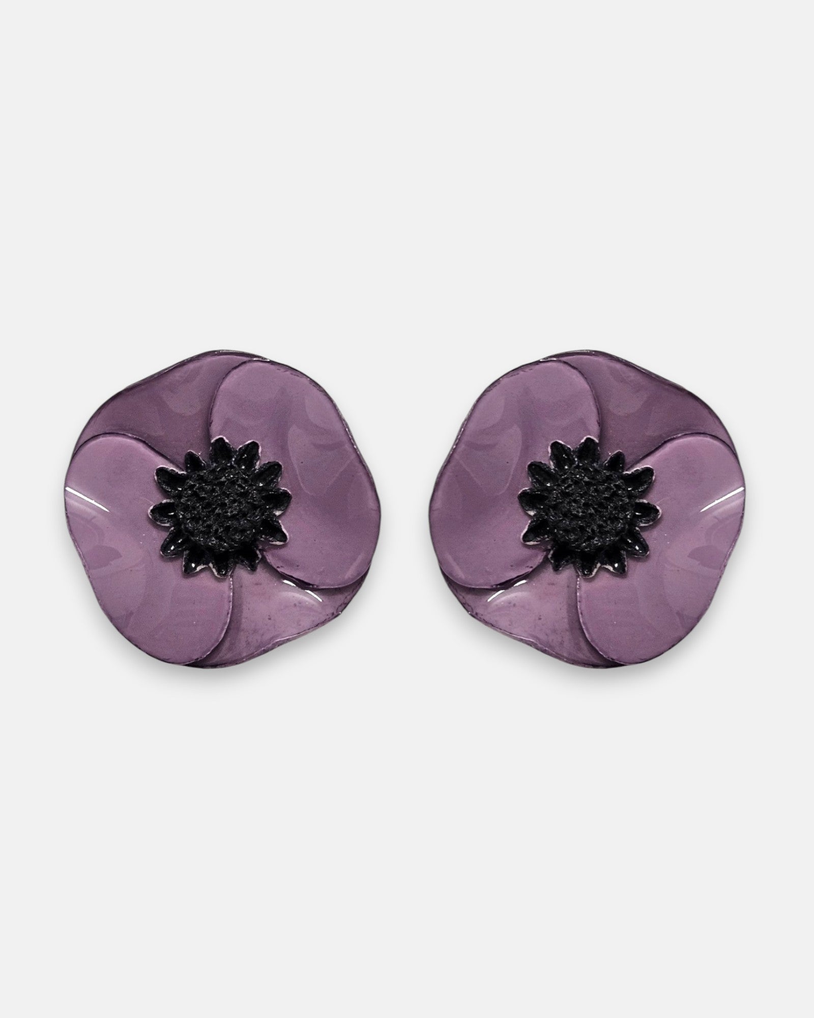 par de pendientes de clip con forma de flor de amapola de Ciléa Paris, detallando sus pétalos de resina esmaltada en tono violeta medio y su centro negro estrellado.