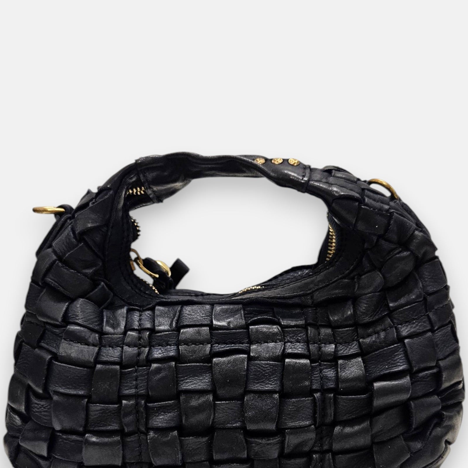 bolso hobo de piel negra trenzada a mano de Campomaggi, destacando su textura tridimensional y su asa superior con tachuelas doradas.