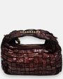 bolso Agnese pequeño de piel elaborada a mano, destacando su textura tridimensional y su asa superior con tachuelas doradas.